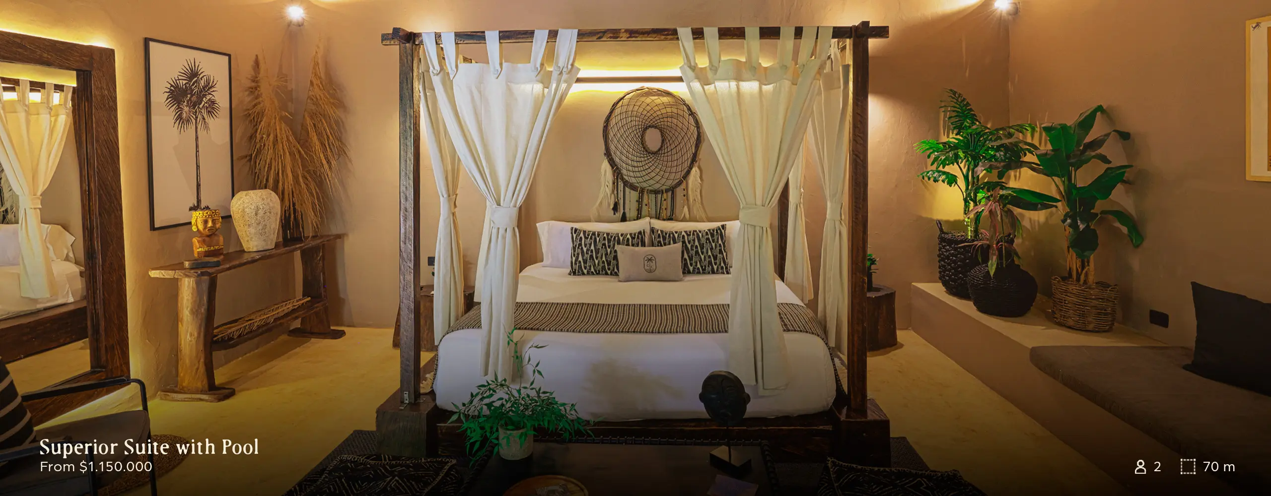 Luxurious four-poster bed with white curtains in a warm, tropical-themed suite, surrounded by plants and soft lighting.